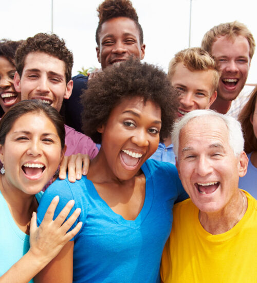 Outdoor Portrait Of Multi-Ethnic Crowd Smiling To Camera
